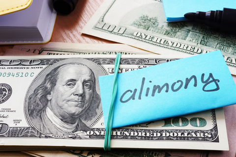 Hundred dollar bills wrapped with note that says alimony